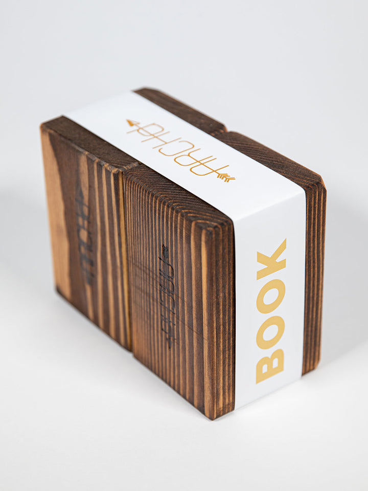 Back view of ARCHd handmade wood bookend set packaged with white paper branded sleeve on white background