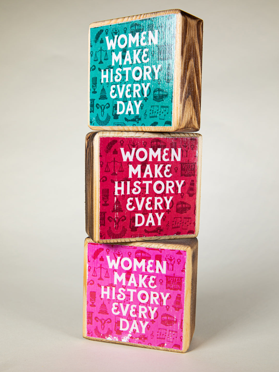 three wood blocks stacked in a tower on a cream background