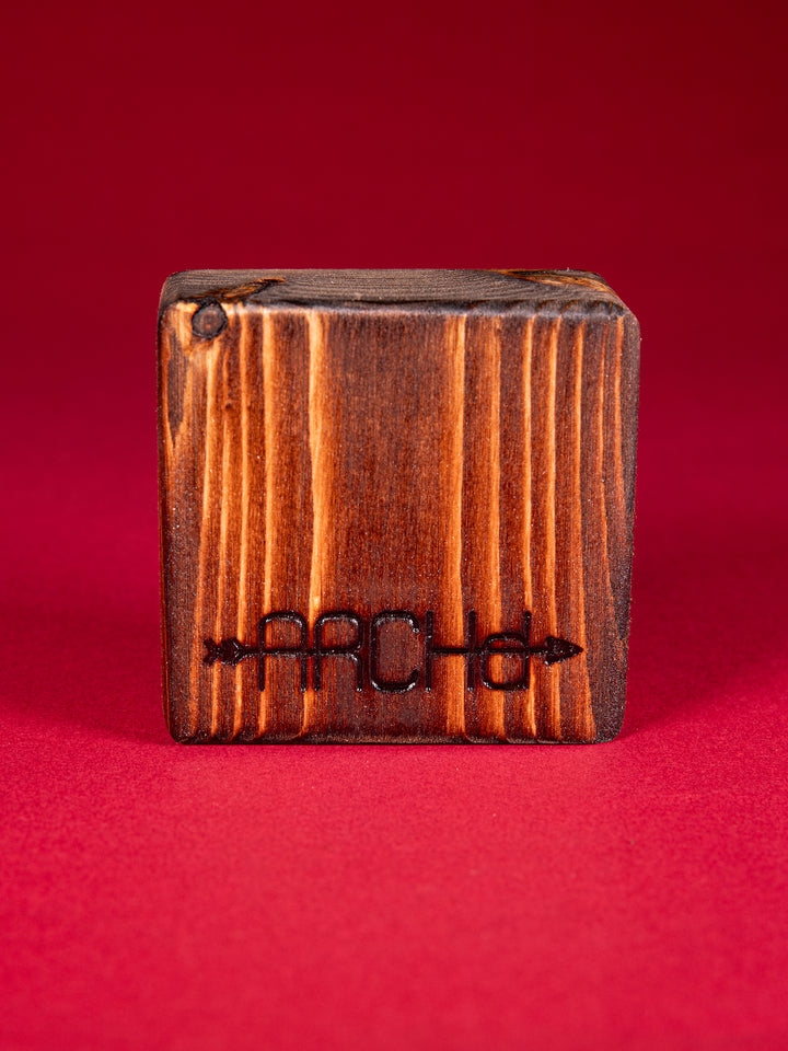 Back view of a stained bood block with an ARCHd logo branded on the bottom on a red background