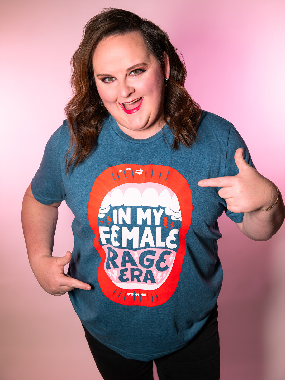Kristen modeling teal crew neck unisex t-shirt with lips, open mouth red lips illustration and saying, "In my female rage era."