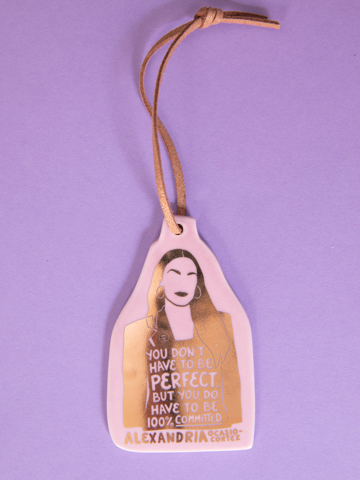 Alexandria Ocasio-Cortez ceramic ornament on purple background. aoc merch