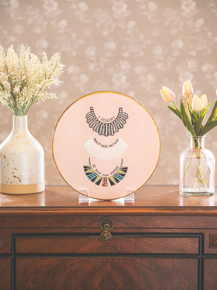 wood round rbg collar art on table top. Ruth Bader Ginsburg art