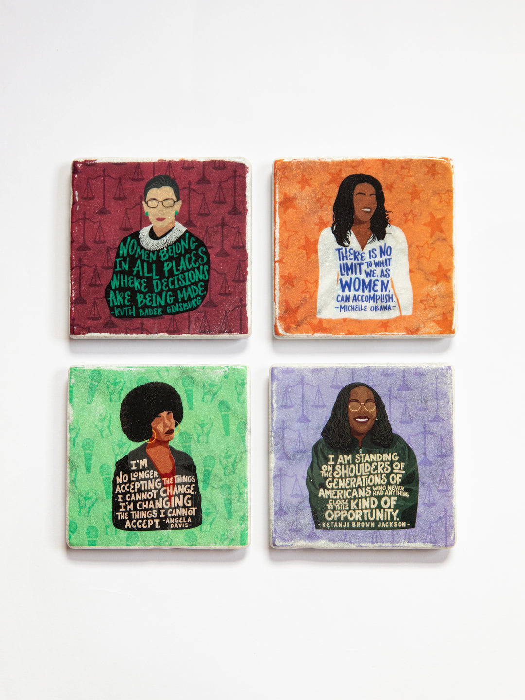 Set of 4 marble coasters. Coasters depict Ruth Bader Ginsburg on a red background, Michelle Obama on an orange background, Angela Davis on a green background, and Ketanji Brown Jackson on a purple background.