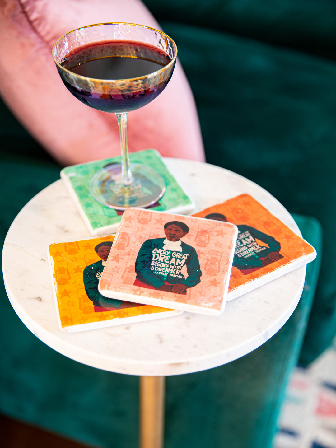 Harriet Tubman coaster set on white table top. Glass of wine sitting on top of a coaster the rest of the coasters stacked next to it. harriet tubman art