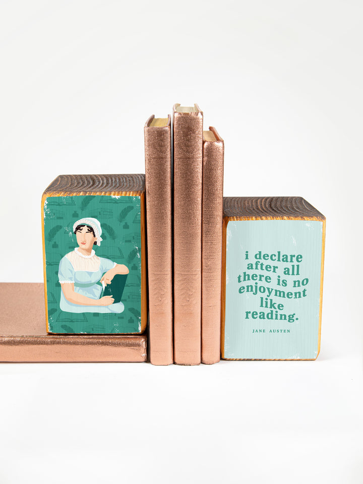 Wood bookends featuring original illustration of English novelist, Jane Austen, paired with Elizabeth Bennet quote from Pride and Prejudice, "I declare after all there is no enjoyment like reading." on a white background. Jane Austen gifts