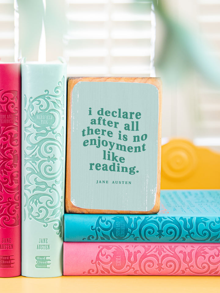 close up of Jane Austen quote bookend on a gold side table holding up two books and sitting on two books, quote reads I declare after all there is no enjoyment like reading. Jane Austen gifts