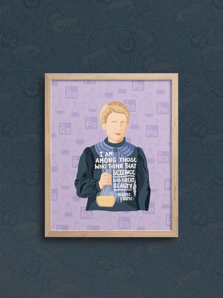 illustration of Marie Curie with her quote, "I am among those who think that science has great beauty." in oak frame hanging on navy blue wallpapered wall. Marie Curie art