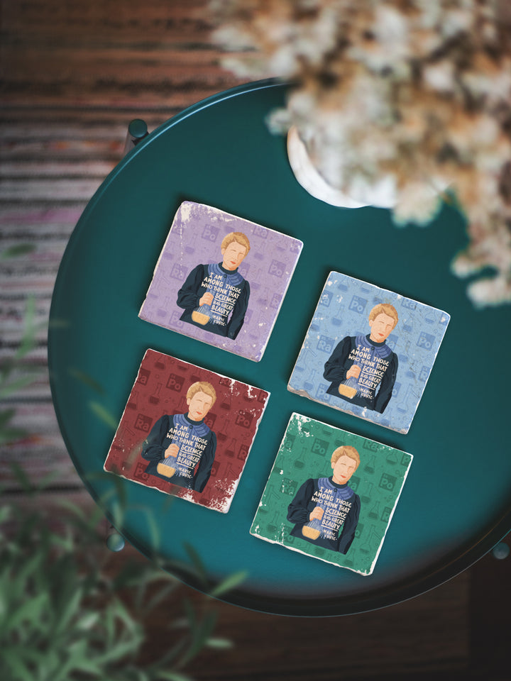 Marie Curie marble coaster set in purple, gree, maroon and light blue on a green table with plants. Marie Curie art