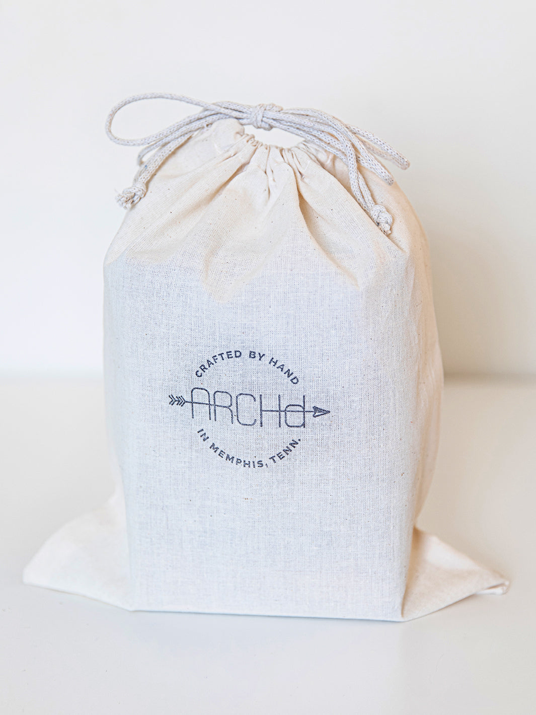 Cotton double string muslin bag with ARCHd logo stamped in black on white background