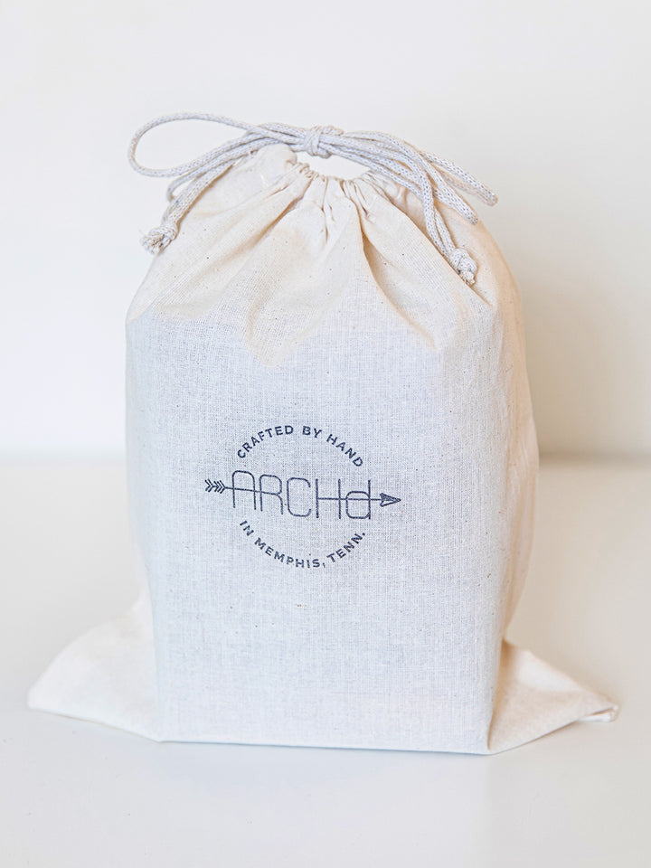 white double drawstring cotton muslin bag with ARCHd stamp in black