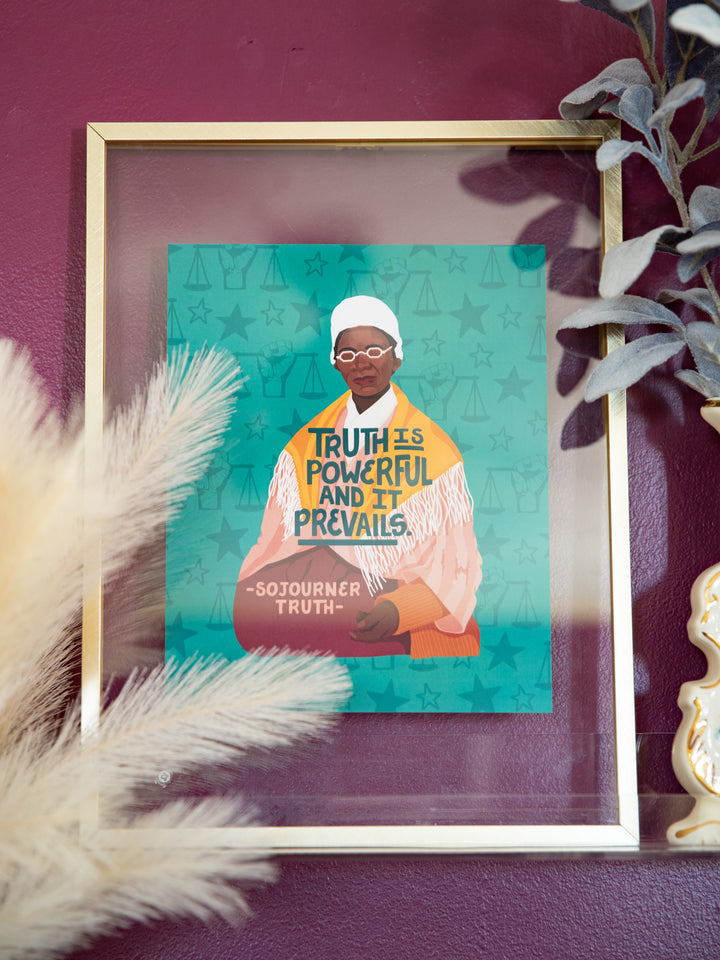 Sojourner Truth illustrated art print in gold frame leaning on purple wall in between two flower vases. Sojourner Truth art