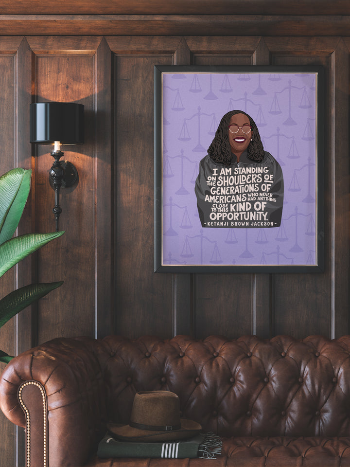 Large poster print of Ketanji Brown Jackson on wood wall hanging over leather sofa. Ketanji Brown Jackson art