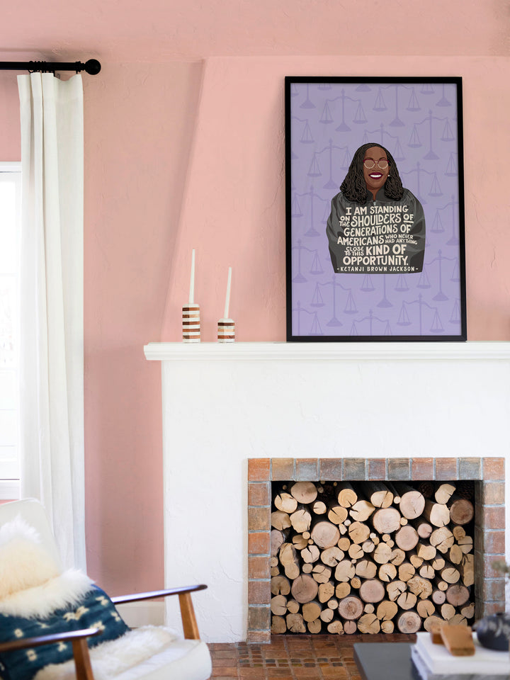 framed print hanging above a wood filled fireplace. Ketanji Brown Jackson art