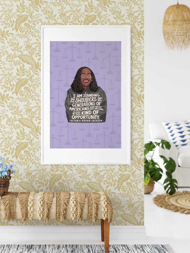 Large poster print of Ketanji Brown Jackson on yellow floral wallpaper over tan bench. Ketanji Brown Jackson art